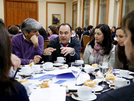Profesionales de la Universidad sentados conversando en La UC Dialoga.