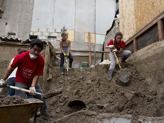 Tres voluntarios excavando la tierra con una pala.